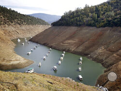 FILE - In this Oct. 30, 2014, file photo, houseboats float in the drought-lowered waters of Oroville Lake near Oroville, Calif. Rainstorms grew more erratic and droughts much longer across most of the U.S. West over the past half-century as climate change warmed the planet, according to a sweeping government study released, Tuesday, April 6, 2021, that concludes the situation in the region is worsening.(AP Photo/Rich Pedroncelli, File)