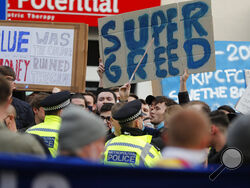 Chelsea fans protest against Chelsea's decision to be included amongst the clubs attempting to form a new European Super League before the English Premier League soccer match between Chelsea and Brighton and Hove Albion outside Stamford Bridge stadium in London, Tuesday, April 20, 2021. (AP Photo/Frank Augstein, Pool)