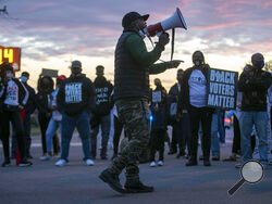 Tony Riddick addresses demonstrators at the intersection of Ehringhaus Street and Road Street during a march on Friday, April 23, 2021, in Elizabeth City, N.C. Authorities say seven North Carolina deputies have been placed on leave in the aftermath of a Black man being shot and killed by members of their department serving drug-related search and arrest warrants. The disclosure comes as calls increase for the release of deputy body camera footage amid signs that Andrew Brown Jr. was shot in the back and kil