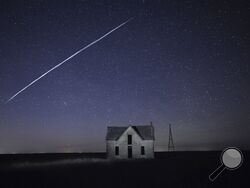 File-In this photo taken May 6, 2021, with a long exposure, a string of SpaceX StarLink satellites passes over an old stone house near Florence, Kan. The train of lights was actually a series of relatively low-flying satellites launched by Elon Musk's SpaceX as part of its Starlink internet service earlier this week. (AP Photo/Reed Hoffmann, File)