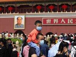 A man and child wearing masks visit Tiananmen Gate near the portrait of Mao Zedong in Beijing on May 3, 2021. China’s population growth is falling closer to zero as fewer couples have children, the government announced Tuesday, May 11, 2021, adding to strains on an aging society with a shrinking workforce. (AP Photo/Ng Han Guan)