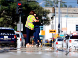 Two people hug on Younger Avenue outside the scene of a shooting in San Jose, Calif., on Wednesday, May, 26. 2021. An employee opened fire Wednesday at a California railyard serving Silicon Valley, killing multiple people before ending his own life, authorities said. The suspect was an employee of the Valley Transportation Authority, which provides bus, light rail and other transit services throughout Santa Clara County, the most populated county in the Bay Area, authorities said. (Randy Vazquez/Bay Area Ne