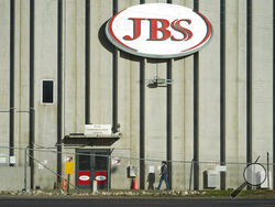 FILE - In this Oct. 12, 2020 file photo, a worker heads into the JBS meatpacking plant in Greeley, Colo. A weekend ransomware attack on the world’s largest meat company is disrupting production around the world just weeks after a similar incident shut down a U.S. oil pipeline. The White House confirms that Brazil-based meat processor JBS SA notified the U.S. government Sunday, May 30, 2021, of a ransom demand from a criminal organization likely based in Russia. (AP Photo/David Zalubowski, File)