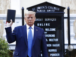 FILE - In this June 1, 2020, file photo President Donald Trump holds a Bible as he visits outside St. John's Church across Lafayette Park from the White House in Washington. An internal investigation has determined that the decision to clear racial justice protestors from an area in front of the White House last summer was not influenced by then-President Donald Trump’s plans for a photo opportunity at that spot. The report released Wednesday by the Department of Interior’s Inspector General concludes that 