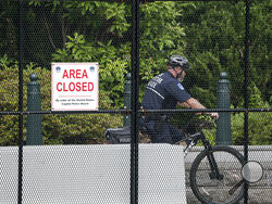 A U.S. Capitol Police officer patrols the barricaded perimeter of the Capitol grounds in Washington, Monday, June 14, 2021. (AP Photo/J. Scott Applewhite)