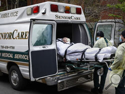 FILE - In this April 17, 2020, file photo, a patient is loaded into an ambulance by emergency medical workers outside Cobble Hill Health Center in the Brooklyn borough of New York. Deaths among Medicare patients in nursing homes soared by more than 30% last year, with two devastating surges eight months apart, a government watchdog reported Tuesday in the most complete assessment yet of the ravages of COVID-19 among its most vulnerable victims. (AP Photo/John Minchillo, File)