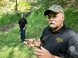 FILE - This Sept. 20, 2018, file photo, Dennis Parada, right, and his son Kem Parada stand at the site of the FBI's dig for Civil War-era gold in Dents Run, Pa. Court documents unsealed Thursday, June 24, 2021, show that an FBI agent applied for a federal warrant in 2018 to seize a cache of gold that he said had been "stolen during the Civil War" while en route to the U.S. Mint in Philadelphia. The Paradas, co-owners of the treasure-hunting outfit Finders Keepers, have said they believe the FBI found gold a