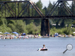 People gather at the Sandy River Delta, in Ore., to cool off during the start of what should be a record-setting heat wave on June 25, 2021. The Pacific Northwest sweltered Friday as a historic heat wave hit Washington and Oregon, with temperatures in many areas expected to top out 25 to 30 degrees above normal in the coming days. (Dave Killen/The Oregonian via AP)