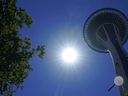 The sun shines near the Space Needle, Monday, June 28, 2021, in Seattle. Seattle and other cities broke all-time heat records over the weekend, with temperatures soaring well above 100 degrees Fahrenheit (37.8 Celsius). (AP Photo/Ted S. Warren)