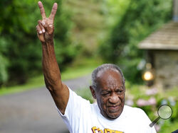 Bill Cosby gestures outside his home in Elkins Park, Pa., Wednesday, June 30, 2021, after being released from prison. Pennsylvania's highest court has overturned comedian Cosby's sex assault conviction. The court said Wednesday, that they found an agreement with a previous prosecutor prevented him from being charged in the case. The 83-year-old Cosby had served more than two years at the state prison near Philadelphia and was released.(AP Photo/Matt Rourke)