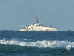 A U.S. Coast Guard cutter patrols the area of debris from a 737 cargo plane that crashed off Oahu, Friday, July 2, 2021, near Honolulu. The plane made an emergency landing in the Pacific Ocean off the coast of Hawaii early Friday and both people on board were rescued. The pilots of the Transair Flight 810 reported engine trouble and were attempting to return to Honolulu when they were forced to land the Boeing 737 in the water, the Federal Aviation Administration said in a statement. (Craig T. Kojima/Honolu