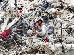 A search and rescue team member moves through the rubble of the Champlain Towers South condo, Wednesday, July 7, 2021. (Al Diaz/Miami Herald via AP)