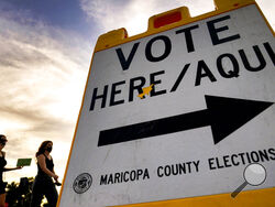 FILE - In this Nov. 3, 2020, file photo voters deliver their ballot to a polling station in Tempe, Ariz. An Associated Press investigation has found county election officials throughout Arizona have identified fewer than 200 cases of potential voter fraud from last year's presidential election that require review by local prosecutors. The findings undermine claims by former President Donald Trump and his allies that widespread fraud is to blame for his loss in Arizona. (AP Photo/Matt York, File)