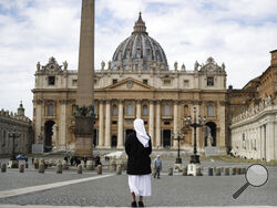 FILE - In this Sunday, March 21, 2021 filer, a nun stands in St. Peter's Square at the Vatican. Vatican prosecutors have alleged a jaw-dropping series of scandals in launching the biggest criminal trial in the Vatican’s modern history, which opens Tuesday in a modified courtroom in the Vatican Museums. The once-powerful cardinal and nine other people are accused of bleeding the Holy See of tens of millions of dollars in donations through bad investments, deals with shady money managers and apparent favors t