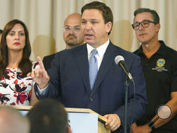 In this Aug. 10, 2021, photo, Florida Gov. Ron DeSantis answers questions related to school openings and the wearing of masks in Surfside, Fla. Top Republicans are battling school districts in their own states’ urban, heavily Democratic areas over whether students should be required to mask up as they head back to school. (AP Photo/Marta Lavandier)