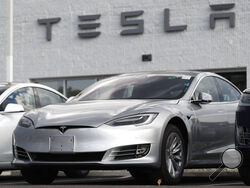 FILE - This July 8, 2018, file photo shows Tesla 2018 Model 3 sedans sitting on display outside a Tesla showroom in Littleton, Colo. The U.S. government has opened a formal investigation into Tesla's Autopilot partially automated driving system, saying it has trouble spotting parked emergency vehicles. The National Highway Traffic Safety Administration announced the action Monday, Aug. 16, 2021, in a posting on its website. (AP Photo/David Zalubowsi, File)