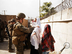 In this photo provided by the U.S. Marine Corps, two civilians during processing through an Evacuee Control Checkpoint during an evacuation at Hamid Karzai International Airport, in Kabul, Afghanistan, Wednesday, Aug. 18, 2021. (Staff Sgt. Victor Mancilla/U.S. Marine Corps via AP)