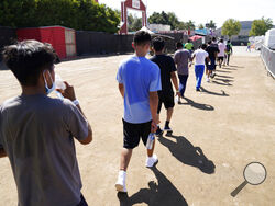 FILE - In this July 2, 2021, file photo, children walk together after a game of soccer at an emergency shelter for migrant children in Pomona, Calif. Five months after the Biden administration declared an emergency and raced to set up shelters to house a record number of children crossing the U.S.-Mexico border alone, kids continue to languish at the sites, while more keep coming, child welfare advocates say. (AP Photo/Marcio Jose Sanchez, Pool, File)