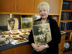 Diane Capone holds a copy of a photograph of her father, Albert "Sonny" Capone as a young boy and her grandfather Al Capone on display at Witherell's Auction House in Sacramento, Calif., Wednesday, Aug. 25, 2021. The granddaughter of the famous mob boss and her two surviving sisters will sell 174 family heirlooms at an Oct. 8 auction titled "A Century of Notoriety: The Estate of Al Capone," that will be held by Witherell's in Sacramento. (AP Photo/Rich Pedroncelli)