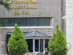 FILE - In this Aug. 13, 2019 file photo, an employee checks a visitor outside the Metropolitan Correctional Center in New York. Federal officials said Thursday, Aug. 26, 2021, they are shutting down the embattled jail in New York City after a slew of problems that came to light following Jeffrey Epstein’s suicide there two years ago. (AP Photo/Mary Altaffer, File)