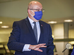 France's Ambassador to Australia Jean-Pierre Thebault gestures as he arrives at Sydney Airport, Saturday Sept. 18, 2021. Thebault has described as a "huge mistake" Australia's surprise cancellation of a major submarine contract in favor of a U.S. deal, in an unprecedented show of anger among the allies. (AP Photo/David Gray)