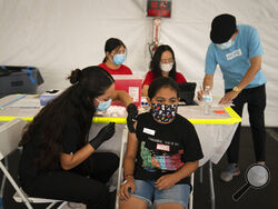 FILE - In this Aug. 28, 2021, file photo, Mayra Navarrete, 13, receives the Pfizer COVID-19 vaccine from registered nurse, Noleen Nobleza at a clinic set up in the parking lot of CalOptima in Orange, Calif. With more than 40 million doses of coronavirus vaccines available, U.S. health authorities said they're confident both seniors and other vulnerable Americans seeking booster shots and parents anticipating approval of initial shots for young children will have easy access. (AP Photo/Jae C. Hong, File)