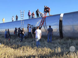 In this photo provided by Kimberly Fossen people work at the scene of an Amtrak train derailment on Saturday, Sept. 25, 2021, in north-central Montana. Multiple people were injured when the train that runs between Seattle and Chicago derailed Saturday, the train agency said. (Kimberly Fossen via AP)