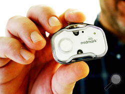 Keith Mathis holds a panic button he helped create as part of CoxHealth's Innovation Accelerators program. Nurses and hundreds of other staff members will soon begin wearing panic buttons at a Missouri hospital where assaults on workers tripled after the onset of the COVID-19 pandemic. (Sara Karnes/The Springfield News-Leader via AP)