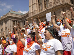 FILE- In this Wednesday, Sept. 1, 2021, file photo, women protest against Texas' restrictive abortion law at the Capitol in Austin, Texas. A federal judge on Friday, Oct. 1, 2021, will consider whether Texas can leave in place the most restrictive abortion law in the U.S., which since September has banned most abortions and sent women racing to get care beyond the borders of the nation's second-largest state. (Jay Janner/Austin American-Statesman via AP)