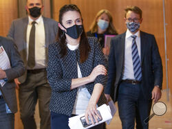 New Zealand Prime Minister Jacinda Ardern arrives with director general of health Dr Ashley Bloomfield, right, for the post-Cabinet press conference at Parliament in Wellington, New Zealand, Monday, Oct. 4, 2021. New Zealand's government has acknowledged what most other countries did long ago, It can no longer completely get rid of the coronavirus. (Mark Mitchell/Pool Photo via AP)