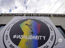 A poster advocating union solidarity hangs from a Costume Designers Guild office building, Monday, Oct. 4, 2021, in Burbank, Calif. The International Alliance of Theatrical Stage Employees (IATSE) overwhelmingly voted to authorize a strike for the first time in its 128-year history. (AP Photo/Chris Pizzello)