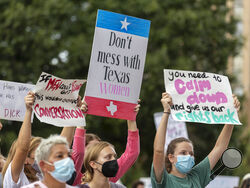 FILE - In this Oct. 2, 2021, file photo, people attend the Women's March ATX rally, at the Texas State Capitol in Austin, Texas. A federal judge has ordered Texas to suspend a new law that has banned most abortions in the state since September. The order Wednesday by U.S. District Judge Robert Pitman freezes for now the strict abortion law known as Senate Bill 8. (AP Photo/Stephen Spillman, File)
