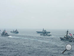 In this photo released by U.S. Navy, US Navy aircraft carrier USS Carl Vinson (CVN 70) and other US and Allies vessels transit the Bay of Bengal as part of MALABAR 2021, on Oct. 12, 2021. China seeks to bring the strategically and symbolically important island back under its control, and the U.S. sees Taiwan in the context of broader challenges from China. (Russel Lindsey/US Navy via AP)