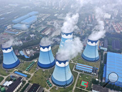 FILE - In this Sept. 27, 2021 file photo, steam billows out of the cooling towers at a coal-fired power station in Nanjing in east China's Jiangsu province. The world's facing an energy crunch. Europe is feeling it worst as natural gas prices skyrocket to five times normal, forcing some factories to hold back production. Reserves depleted last winter haven't been made up, and chief supplier Russia has held back on supplying extra. Meanwhile, the new Nord Stream 2 gas pipeline won't start operating in time t