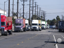 Parked cargo container trucks are seen in a street, Wednesday, Oct. 20, 2021 in Wilmington, Calif. California Gov. Gavin Newsom on Wednesday issued an order that aims to ease bottlenecks at the ports of Los Angeles and Long Beach that have spilled over into neighborhoods where cargo trucks are clogging residential streets. (AP Photo/Ringo H.W. Chiu)