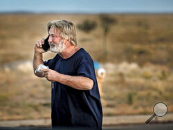 Alec Baldwin speaks on the phone in the parking lot outside the Santa Fe County Sheriff's Office in Santa Fe, N.M., after he was questioned about a shooting on the set of the film "Rust" on the outskirts of Santa Fe, Thursday, Oct. 21, 2021. Baldwin fired a prop gun on the set, killing cinematographer Halyna Hutchins and wounding director Joel Souza, officials said. (Jim Weber/Santa Fe New Mexican via AP)