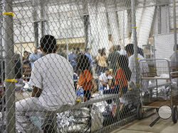 FILE - In this June 17, 2018, file photo provided by U.S. Customs and Border Protection, people who've been taken into custody related to cases of illegal entry into the United States, sit in one of the cages at a facility in McAllen, Texas. The U.S. Justice Department is in talks to pay hundreds of thousands of dollars to each child and parent who was separated under a Trump-era practice of splitting families at the border. (U.S. Customs and Border Protection's Rio Grande Valley Sector via AP, File)