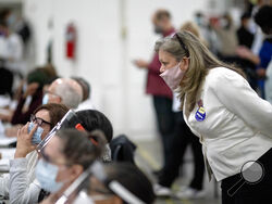 FILE - A Republican election challenger at right watches over election inspectors as they examine a ballot as votes are counted into the early morning hours, Nov. 4, 2020, at the central counting board in Detroit. A review by The Associated Press in the six battleground states disputed by former President Trump has found fewer than 475 cases of potential voter fraud, a minuscule number that would have made no difference in the 2020 presidential election. Democrat Joe Biden won Arizona, Georgia, Michigan, Ne