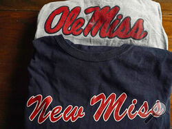  The top t-shirt is emblazoned with one of the University of Mississippi's logos, while the bottom shirt, a New Miss product, sports a logo nearly identical to the university's ubiquitous Ole Miss brand, as photographed Nov. 9, 2021 in Jackson, Miss. The university objects to the trademark application filed by the person marketing the New Miss brand. (AP Photo/Rogelio V. Solis)