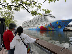 FILE - People pause to look at Norwegian Cruise Line's ship, Norwegian Breakaway, on the Hudson River, in New York, on May 8, 2013. Ten people aboard the cruise ship, approaching New Orleans, have tested positive for COVID-19, officials said Saturday night, Dec. 4, 2021. The Norwegian Breakaway had departed New Orleans on Nov. 28 and is due to return this weekend, the Louisiana Department of Health said in a news release. Over the past week, the ship made stops in Belize, Honduras and Mexico. (AP Photo/Rich
