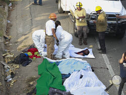 Bodies in bodybags are placed on the side of the road after an accident in Tuxtla Gutierrez, Chiapas state, Mexico, Thursday, Dec. 9, 2021. Mexican authorities say at least 49 people were killed and dozens more injured when a cargo truck carrying Central American migrants rolled over on a highway in southern Mexico. (AP Photo)