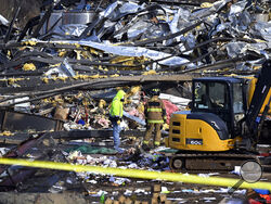 Emergency response workers dig through the rubble of the Mayfield Consumer Products candle factory in Mayfield, Ky., Saturday, Dec. 11, 2021. Tornadoes and severe weather caused catastrophic damage across multiple states late Friday, killing several people overnight. (AP Photo/Timothy D. Easley)