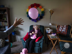Betty Bednarowski, 79, smiles as she bats a balloon back and forth with a nursing assistant at home, Tuesday, Nov. 30, 2021, in Rotterdam Junction, N.Y. It's been a year since her family took her out of a nursing home locked down against COVID-19 to rescue her from isolation and neglect. (AP Photo/Wong Maye-E)