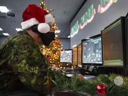 In this photo provided by the North American Aerospace Defense Command, a 22 Wing member is seen showing how they track Santa on his sleigh on Christmas evening during a media preview at the Canadian Forces Base in North Bay on Dec. 9, 2021. In a Christmas Eve tradition going on its 66th year, a wildly popular program run by the U.S. and Canadian militaries is providing real-time updates on Santa's progress around the globe -- and fielding calls from children who want to know St. Nick's exact whereabouts. (