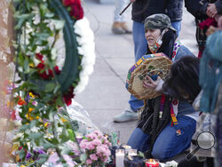 Mourners gather outside the door of a tattoo parlor along South Broadway Tuesday, Dec. 28, 2021, in Denver, one of the scenes of a shooting spree that left multiple people dead—including the suspected shooter Monday evening—and a few more people wounded. The spree spread from the core of Denver to the western suburb of Lakewood where the suspect was shot and killed by police near a busy intersection in a bustling shopping district. (AP Photo/David Zalubowski)