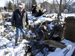Rex Hickman sifts through the rubble of his burned home in Louisville, Colo., on Sunday, Jan. 2, 2022. Hickman, who had lived in the home with his wife for 23 years, found his safe, but little could be salvaged other than a few gold and silver coins. (AP Photo/Thomas Peipert)