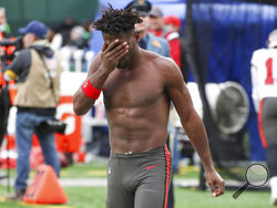 Tampa Bay Buccaneers wide receiver Antonio Brown wipes his face as he leaves the field after throwing his equipment into the stands while his team is on offense during the third quarter of an NFL football game against the New York Jets, Sunday, Jan. 2, 2022, in East Rutherford, N.J. (Andrew Mills/NJ Advance Media via AP)