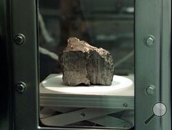 The meteorite labeled ALH84001 sits in a chamber at a Johnson Space Center lab in Houston, Aug. 7, 1996. Scientists say they've confirmed the meteorite from Mars contains no evidence of ancient Martian life. The rock caused a splash 25 years ago when a NASA-led team announced that its organic compounds may have been left by living creatures, however primitive. Researchers chipped away at that theory over the decades. A team of scientists led by Andrew Steele of the Carnegie Institution published their findi