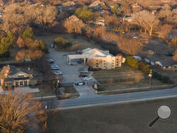 An aerial view of police standing in front of the Congregation Beth Israel synagogue, Sunday, Jan. 16, 2022, in Colleyville, Texas. A man held hostages for more than 10 hours Saturday inside the temple. The hostages were able to escape and the hostage taker was killed. FBI Special Agent in Charge Matt DeSarno said a team would investigate "the shooting incident." (AP Photo/Brandon Wade)