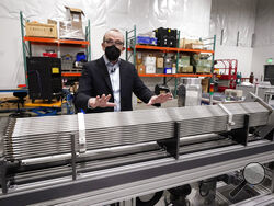 Chris Levesque, president and CEO of TerraPower, a company developing and building small nuclear reactors, displays a fuel assembly model, Thursday, Jan. 13, 2022, in Everett, Wash. The 5-foot model is about one-third actual length and would be vertical when in use, rather than horizontal. By cooling the reactor with liquid sodium, a metal that solidifies at well above room temperature, TerraPower says its relatively small, 345-megawatt plant will be safe and less expensive than conventional, water-cooled n